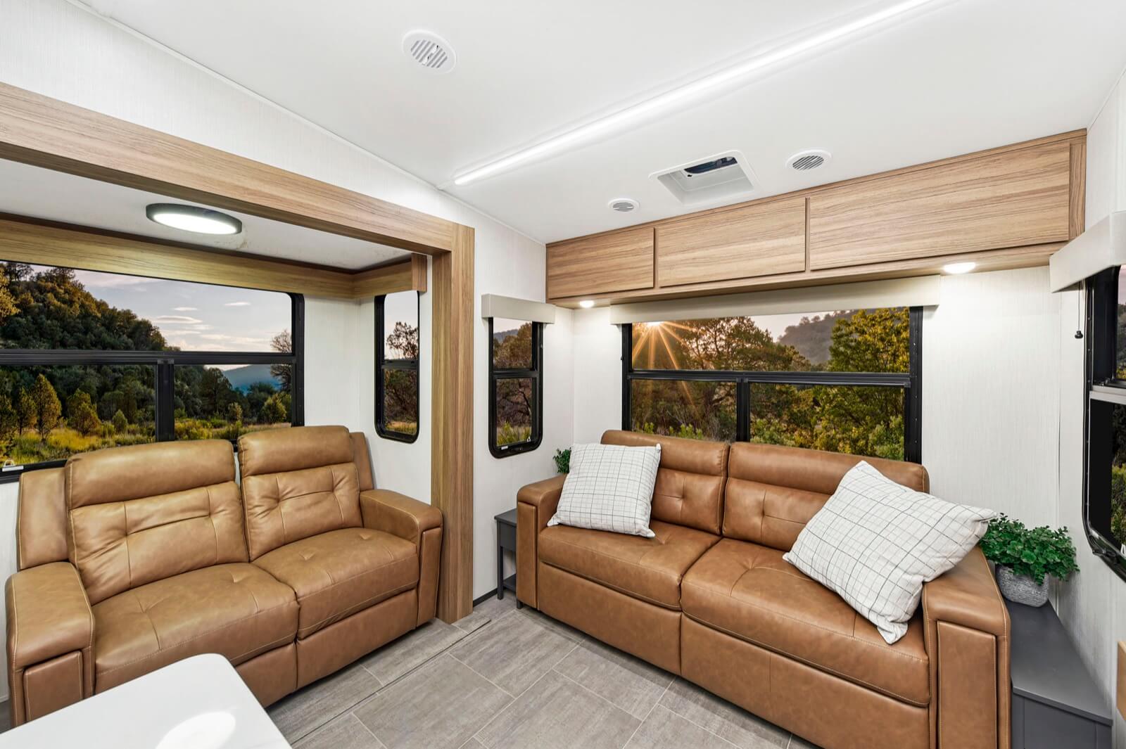 Rear living with burnt orange couches and seamless storage above